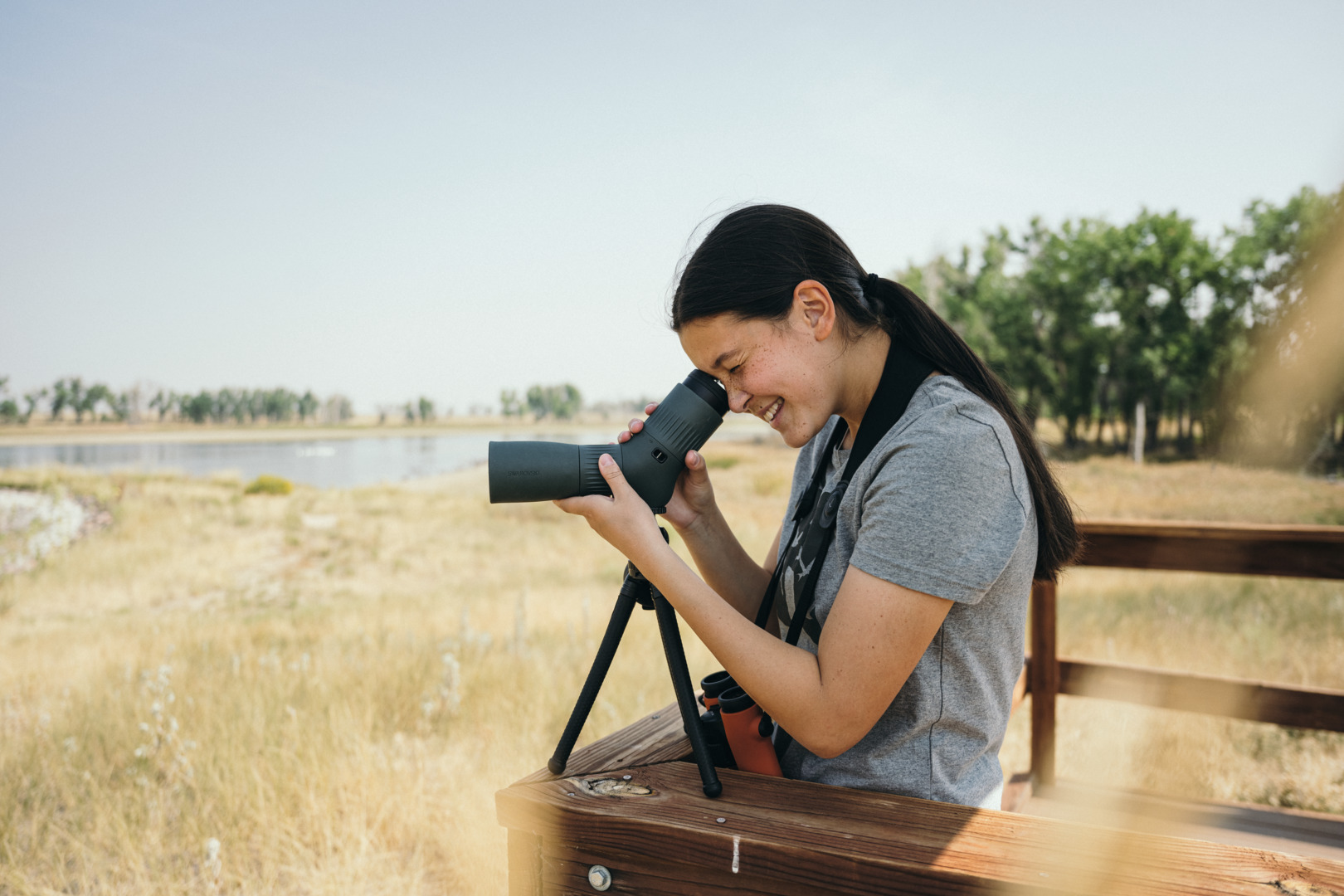 Birder using a compact Swarovski ATC spotting scope on a table tripod