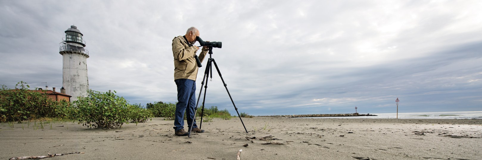 Birdwatcher using a Swarovski ATX spotting scope on a tripod at the beach