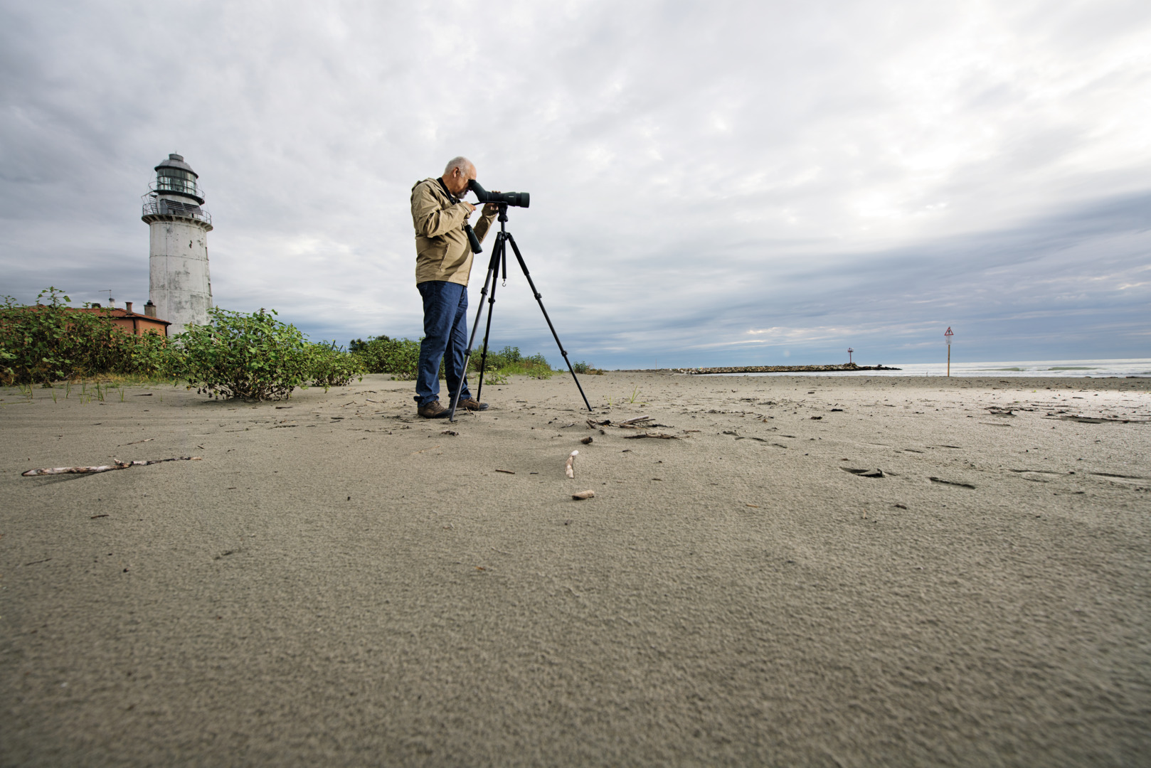 Birdwatcher using a Swarovski ATX spotting scope on a tripod at the beach
